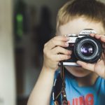 bambino con macchina fotografica bando a scuola di like