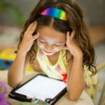 Bambina assorta mentre utilizza il tablet. Nessuno pensa che è una questione di salute.