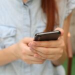 Ragazza concentrata sul proprio smartphone. Le ragazze sono statisticamente più a rischio per quanto riguarda i disturbi alimentari, fenomeni connessi all'isolamento.