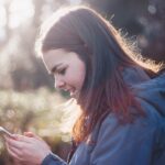 una ragazza naviga online con il proprio smartphone